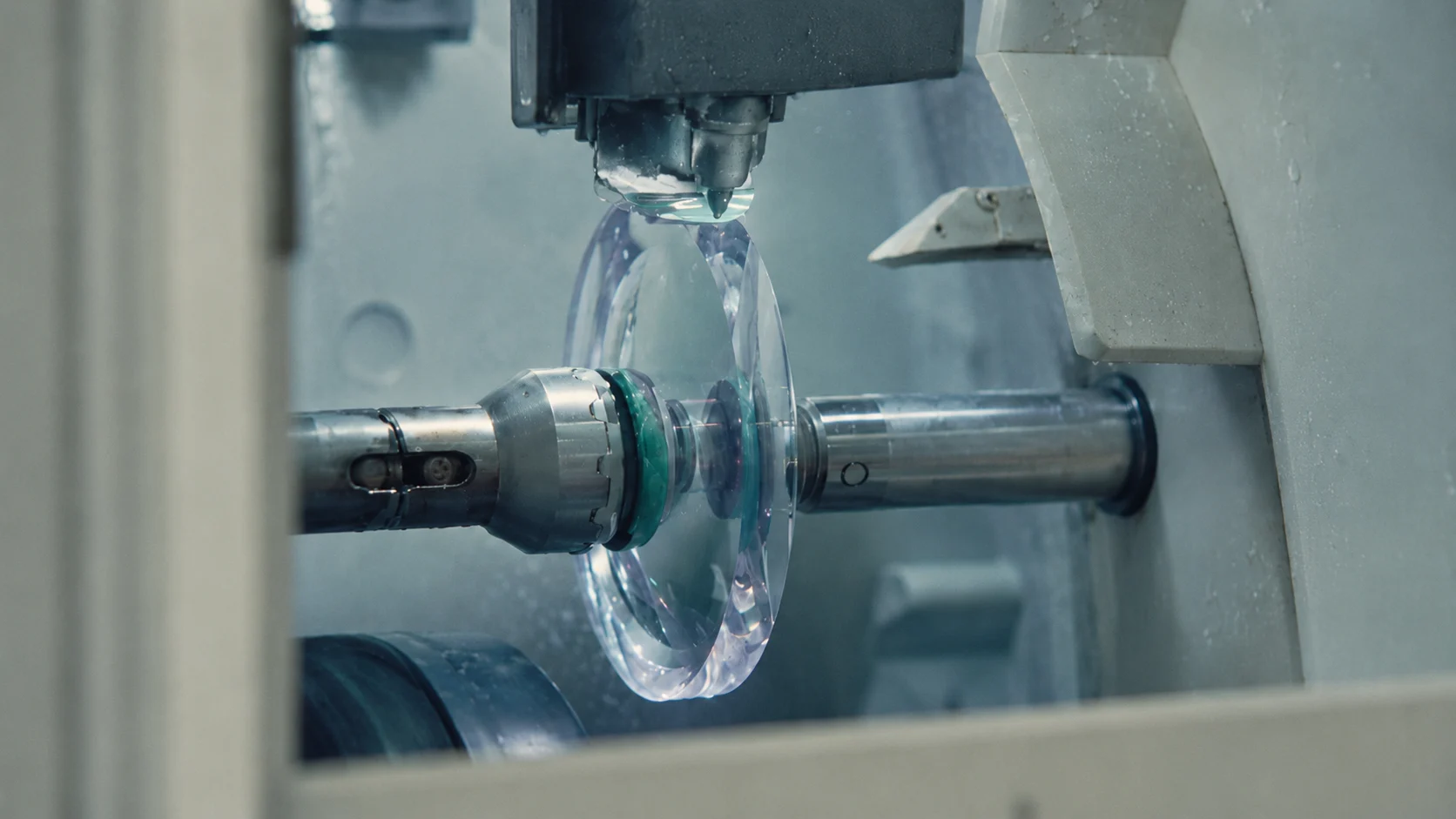 Transparent optical lens mounted in a precision cutting machine